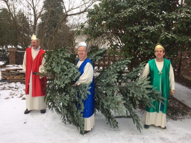The three kings take away the Christmas tree into the snow.